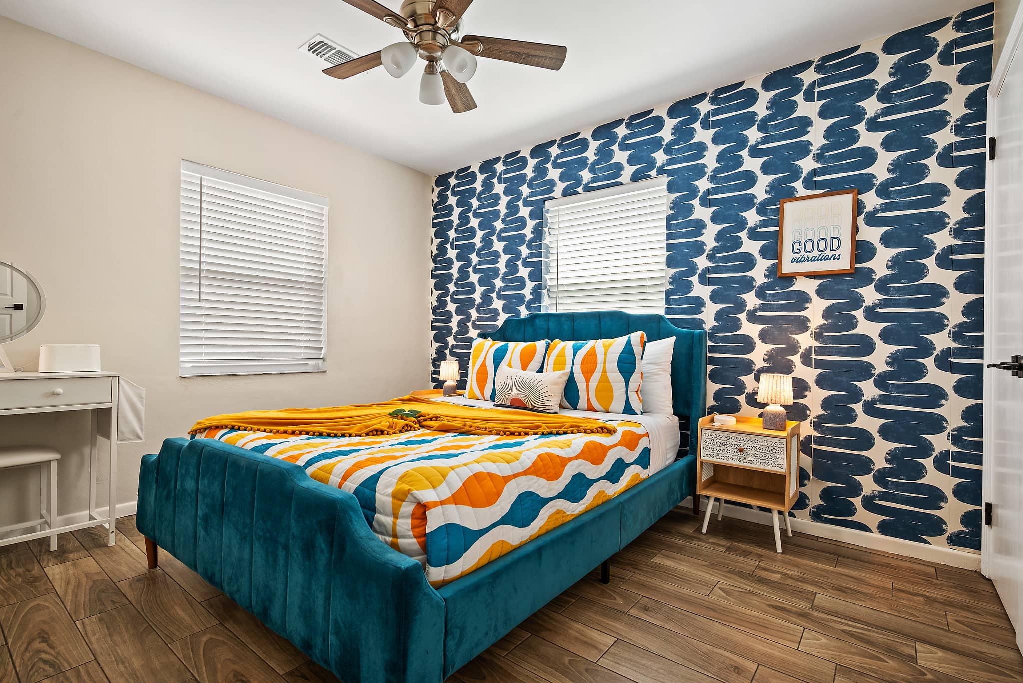 Queen bedroom with luxurious bedding and blue geometric wallpaper in Good Vibrations retro theme at Tropical Disco St. Petersburg Florida